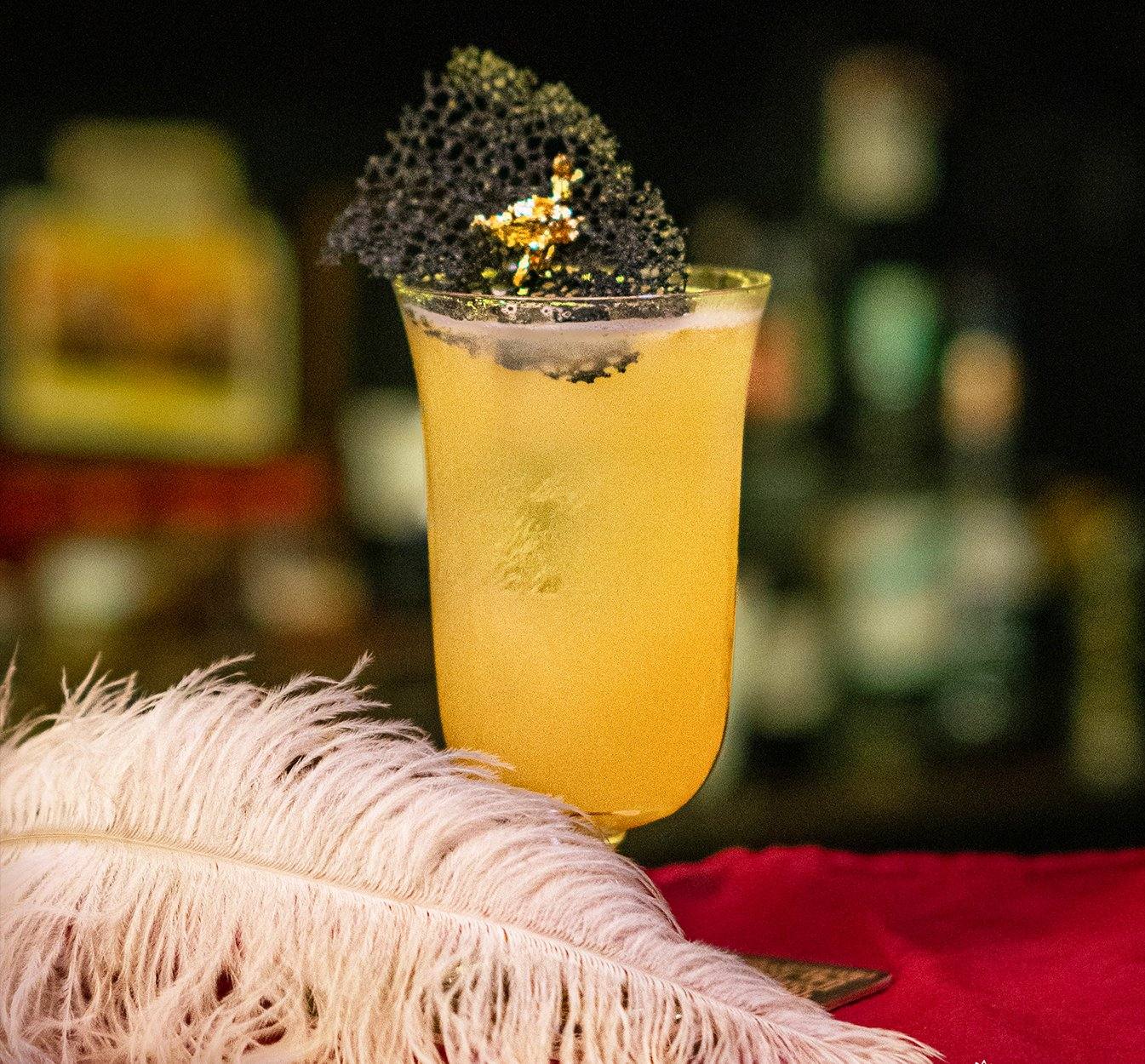 Bees Knees Twist cocktail recipe Ginger Lemongrass Gin Saigon Spirits gold amber feather garnish Vietnam creative cocktail bar